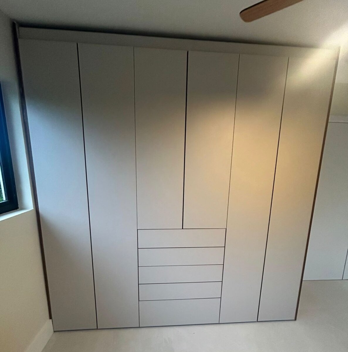 Custom shelving with reflection into an adjoining glass-front closet