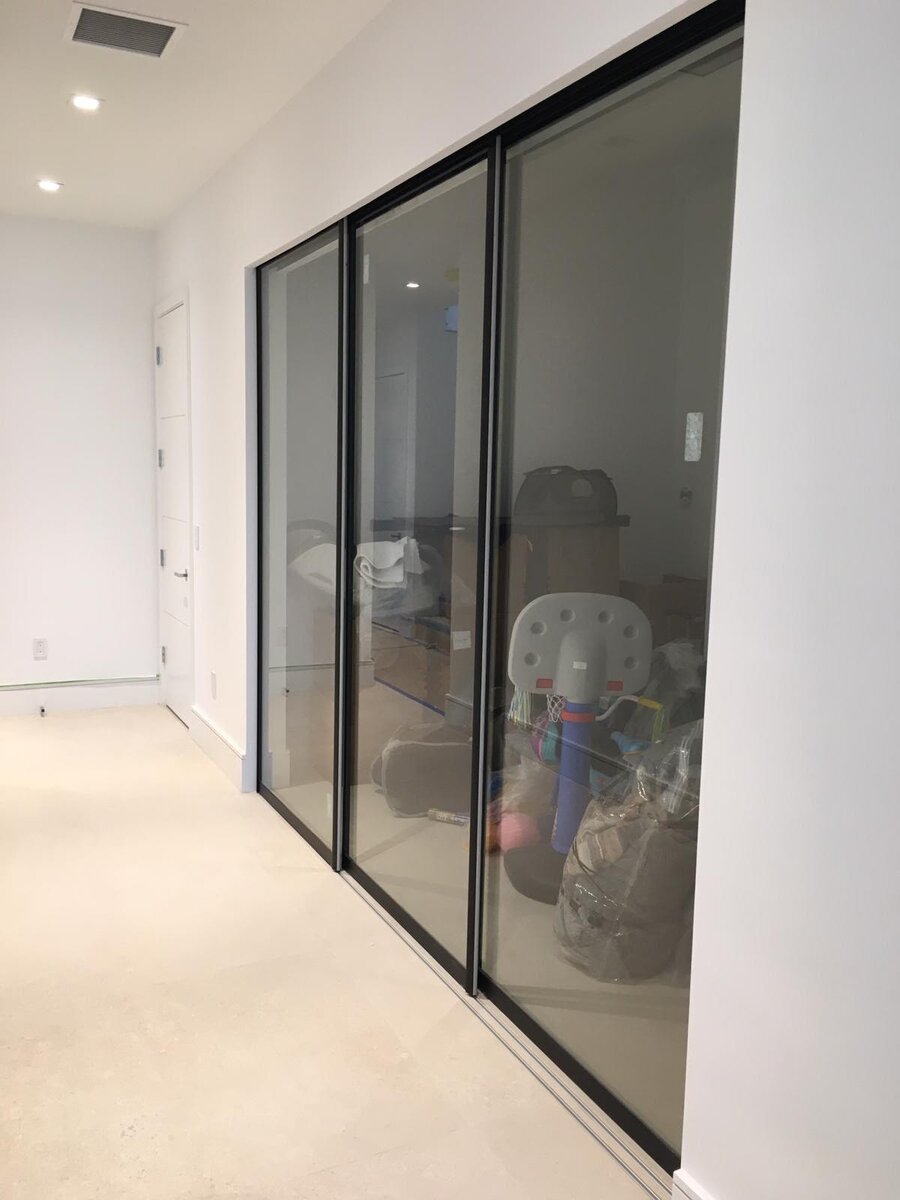 Black-framed glass sliding closet doors in a hallway