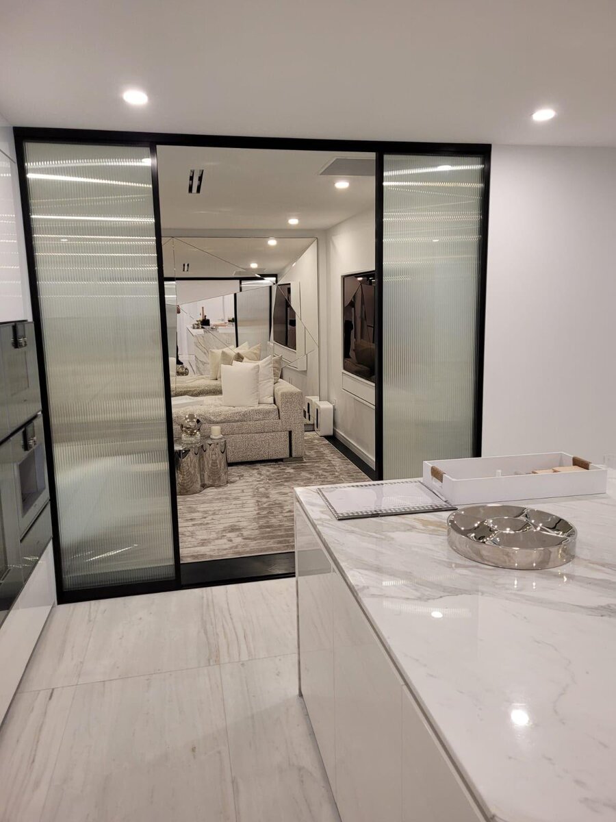 Frosted glass sliding room divider off a kitchen island