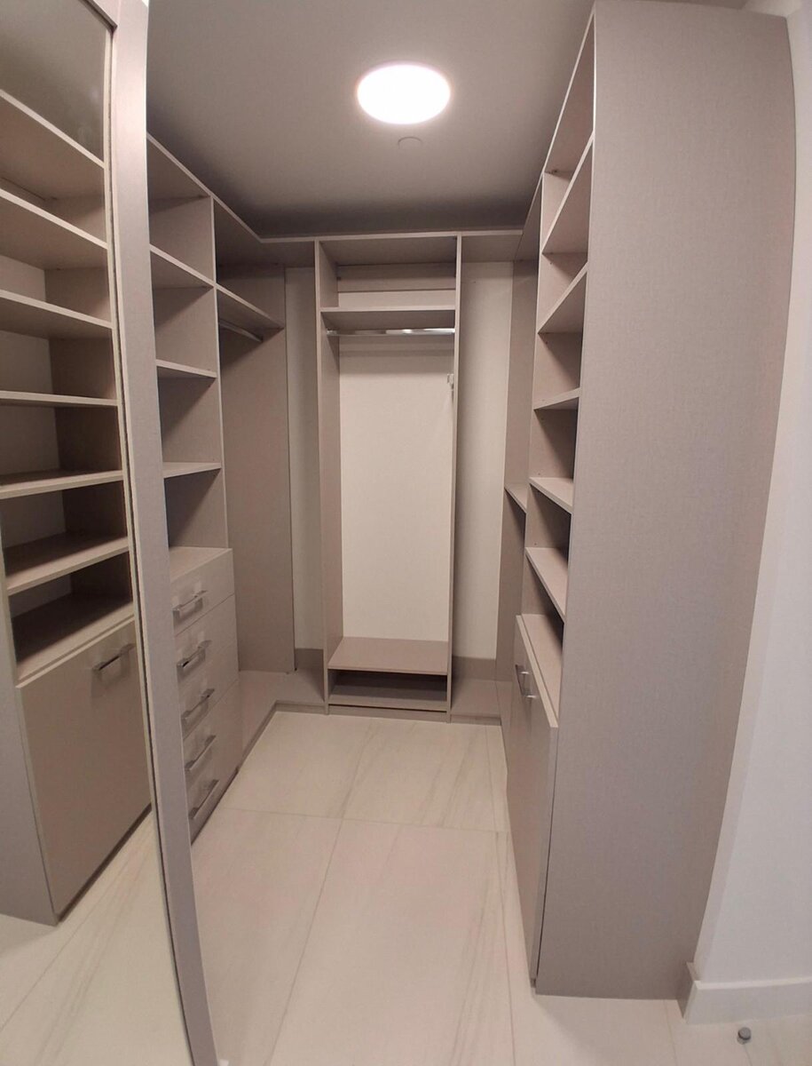 Walk-in closet with corner shelving and full-length mirror