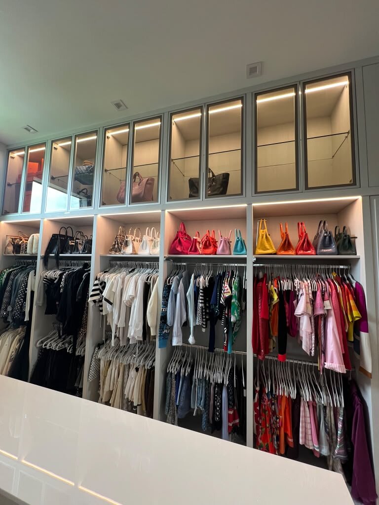 Custom closet filled with organized clothing, bags and accessories